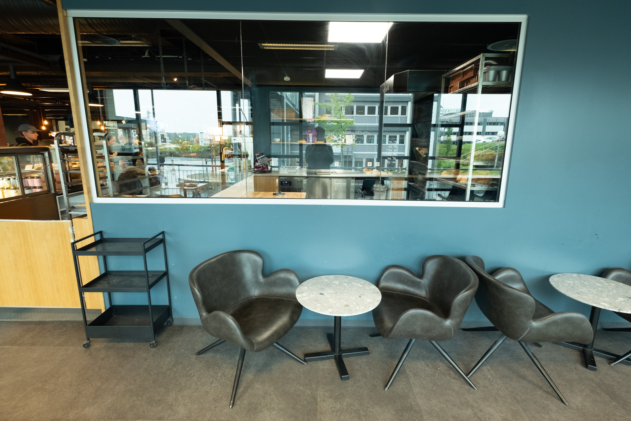 Seating underneath large windows opening up the bakery to the seating area